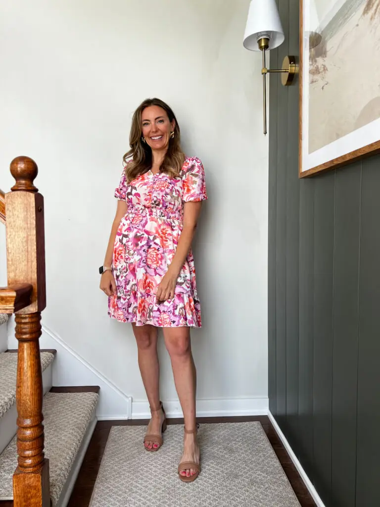 A woman standing on the stairs in her dress.