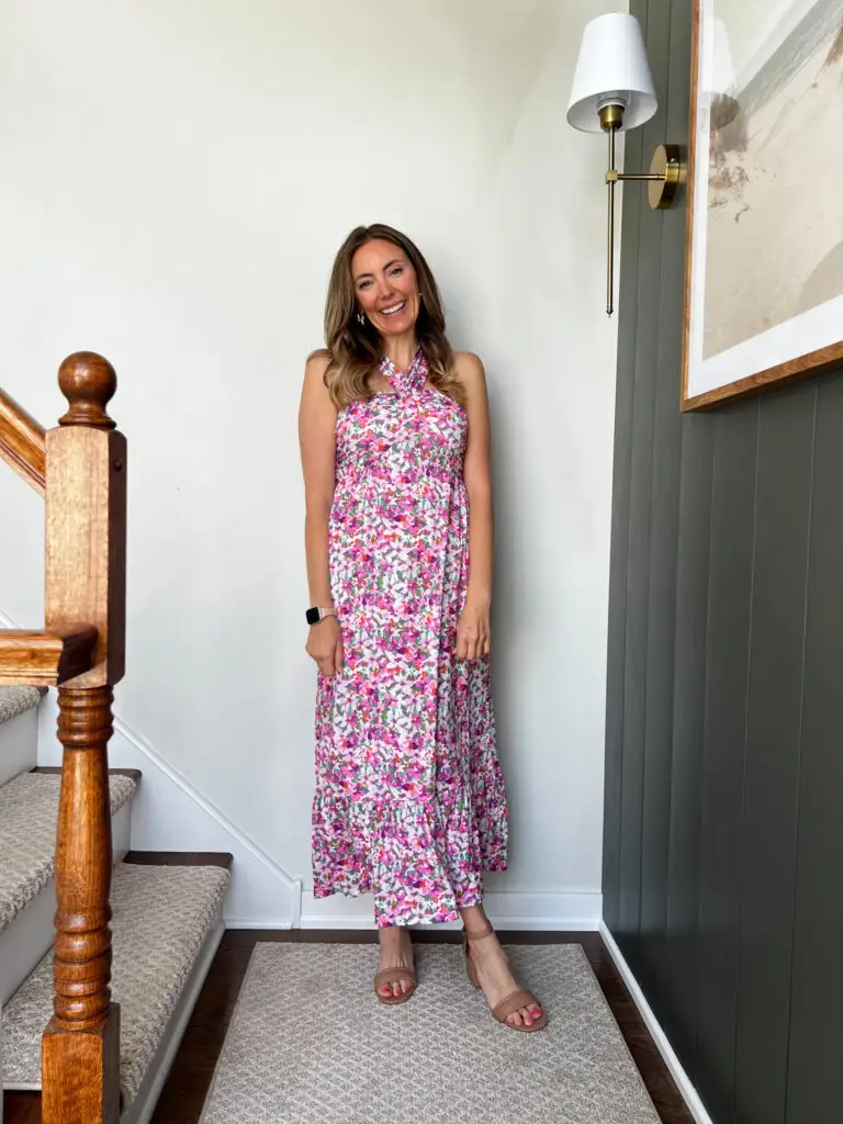A woman standing on the stairs wearing a dress.