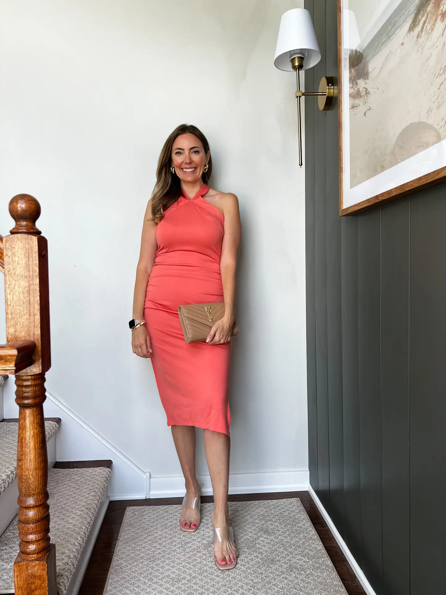A woman in an orange dress standing on steps.