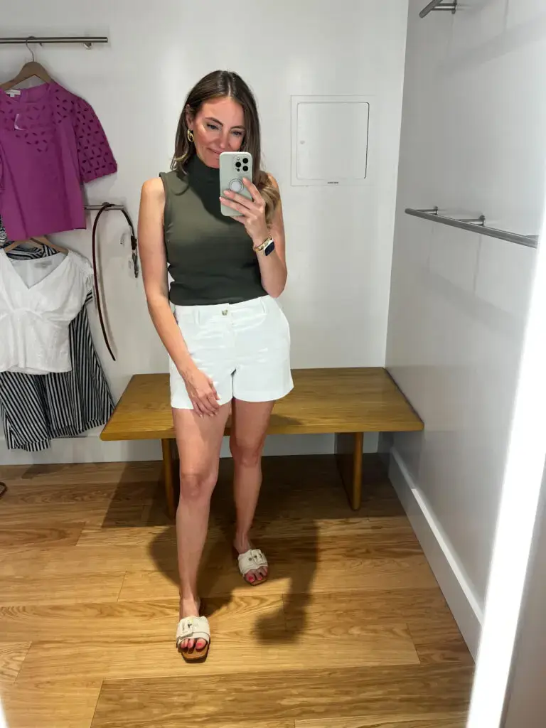 A woman taking a selfie in front of a mirror.
