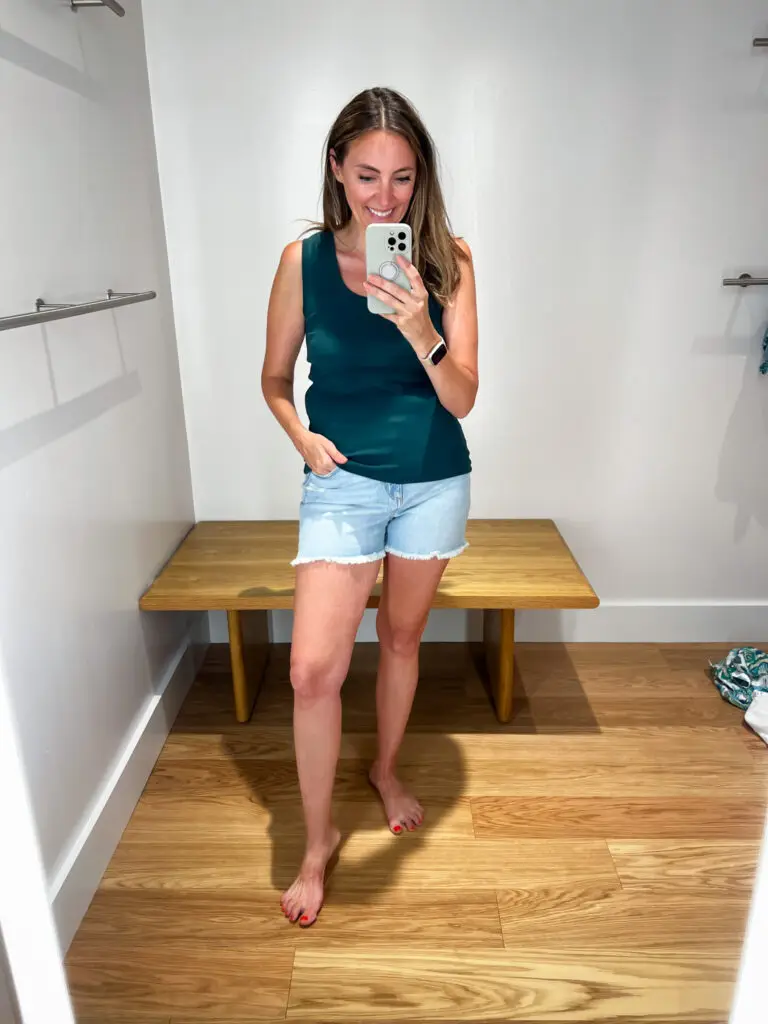 A woman taking a selfie in front of a mirror.