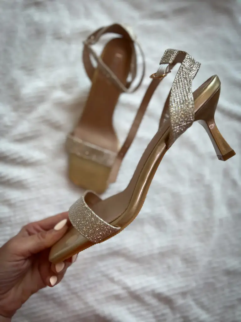 A person holding onto a pair of shoes