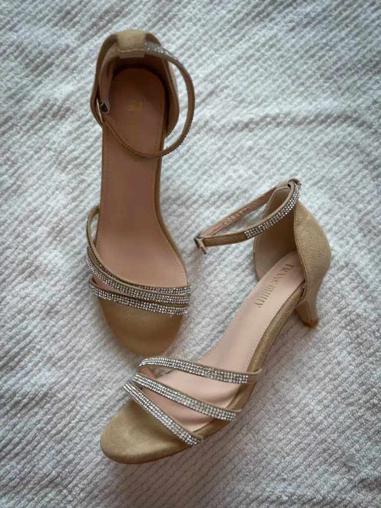 A pair of shoes sitting on top of a bed.