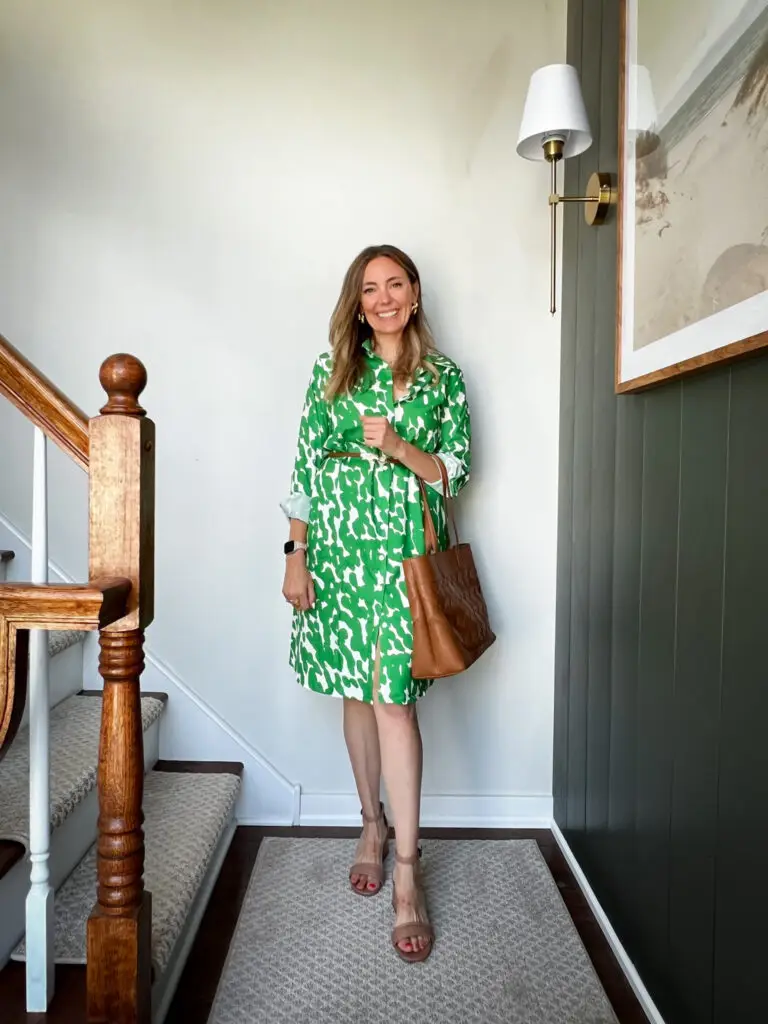 A woman in green dress standing on stairs.