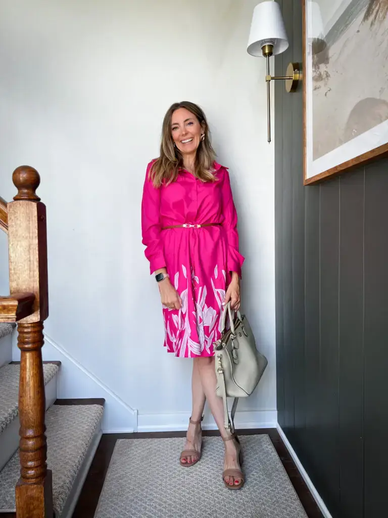 A woman in pink dress standing on stairs.