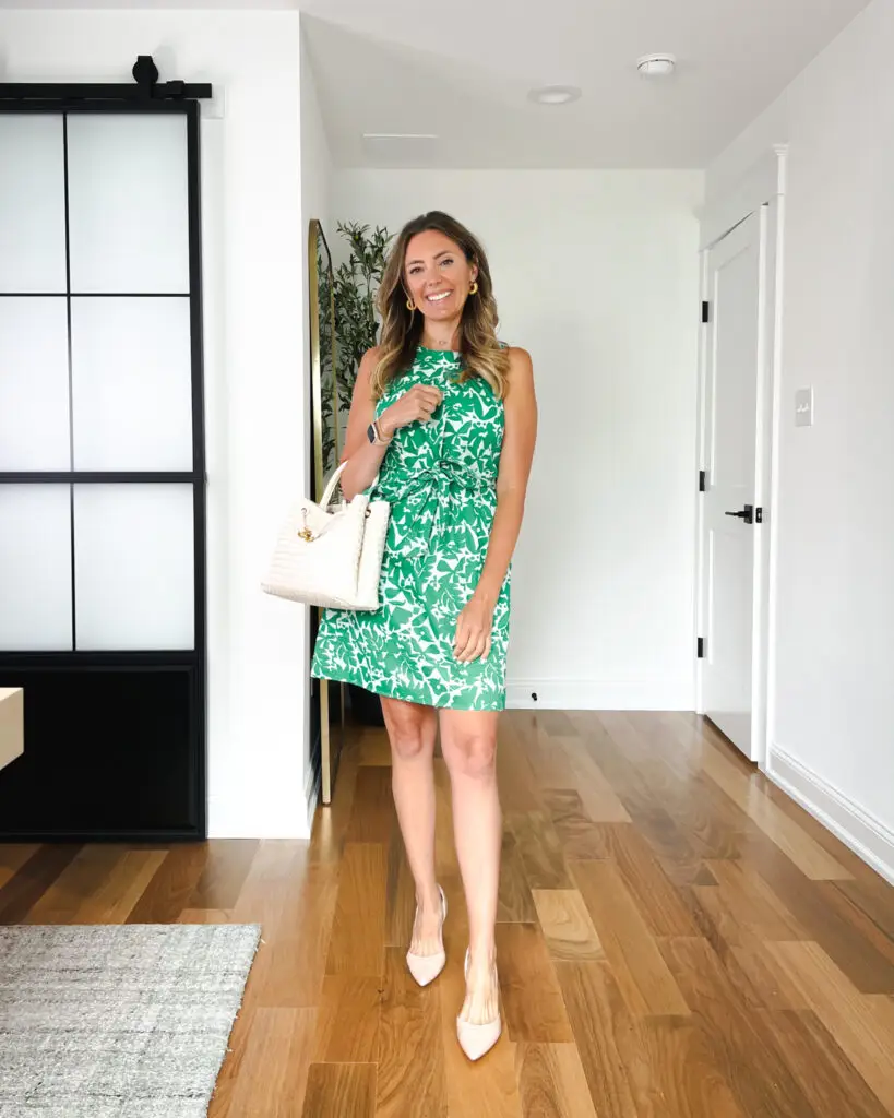 A woman in green dress standing on the floor.