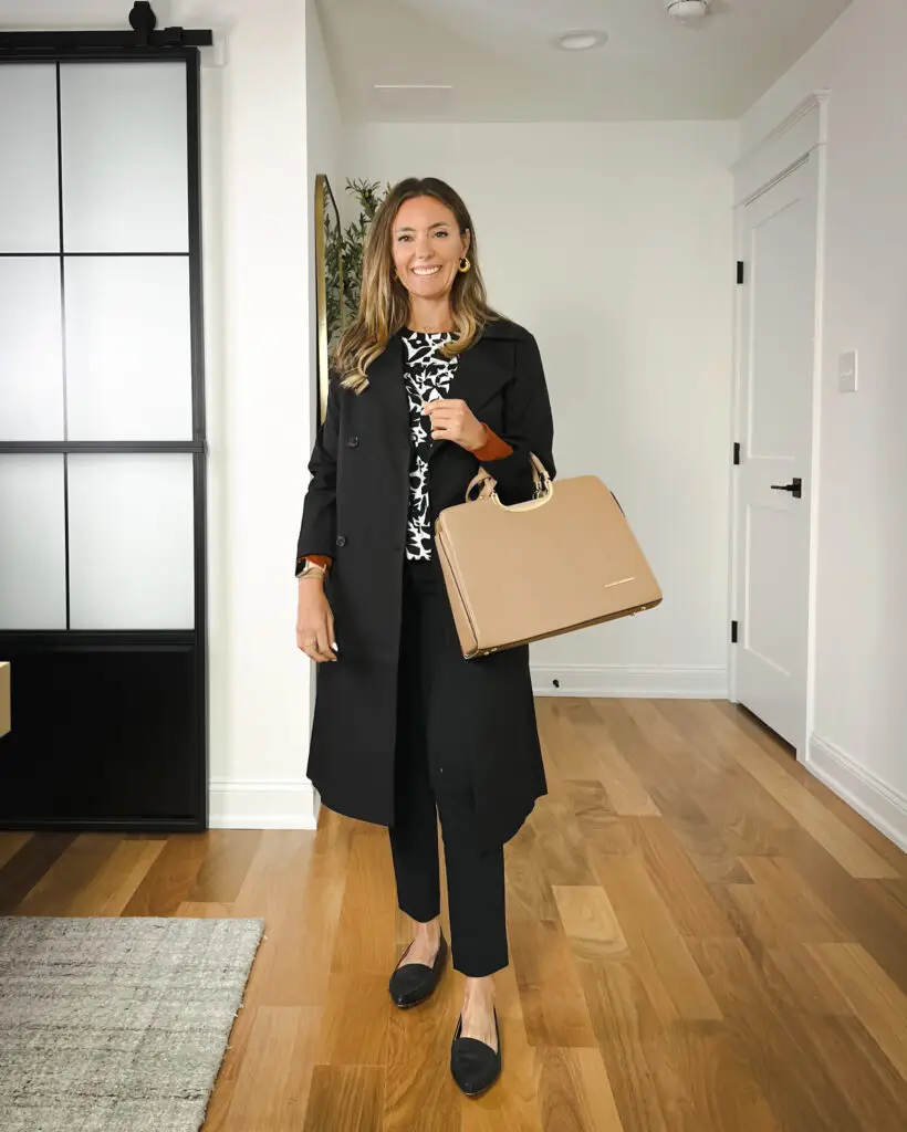A woman standing in front of a door holding onto a bag.