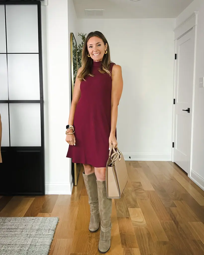 A woman standing in front of a door wearing boots.