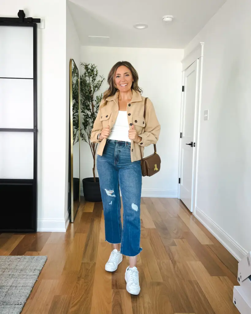 A woman in white shirt and jeans standing on the floor.