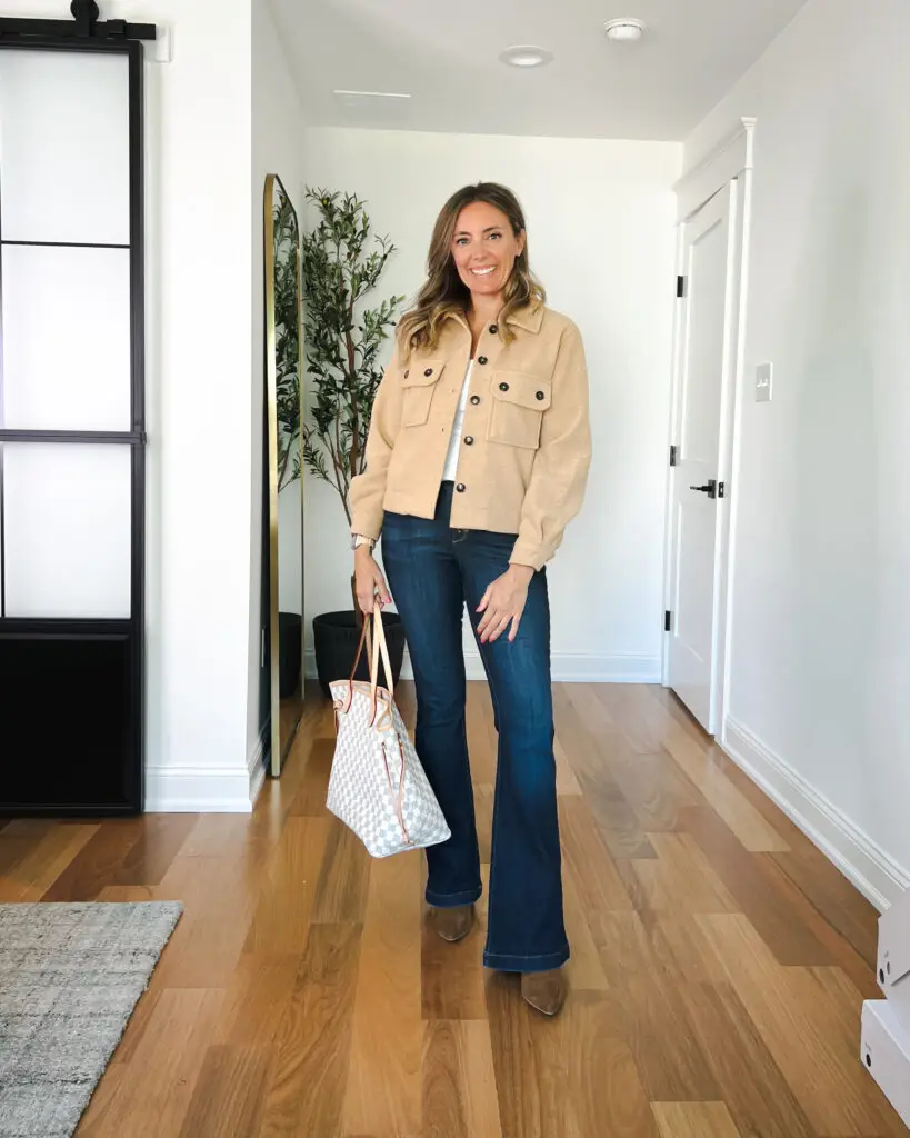 A woman standing in front of a door holding onto some bags