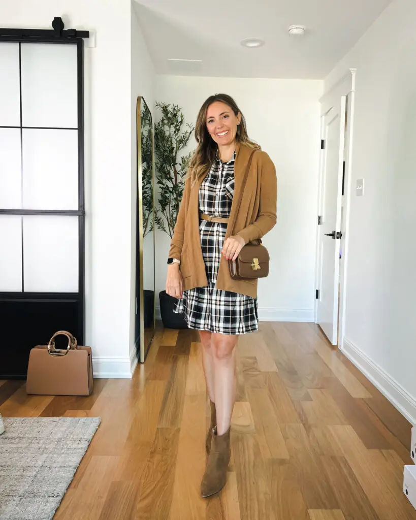 A woman in plaid dress and brown cardigan.