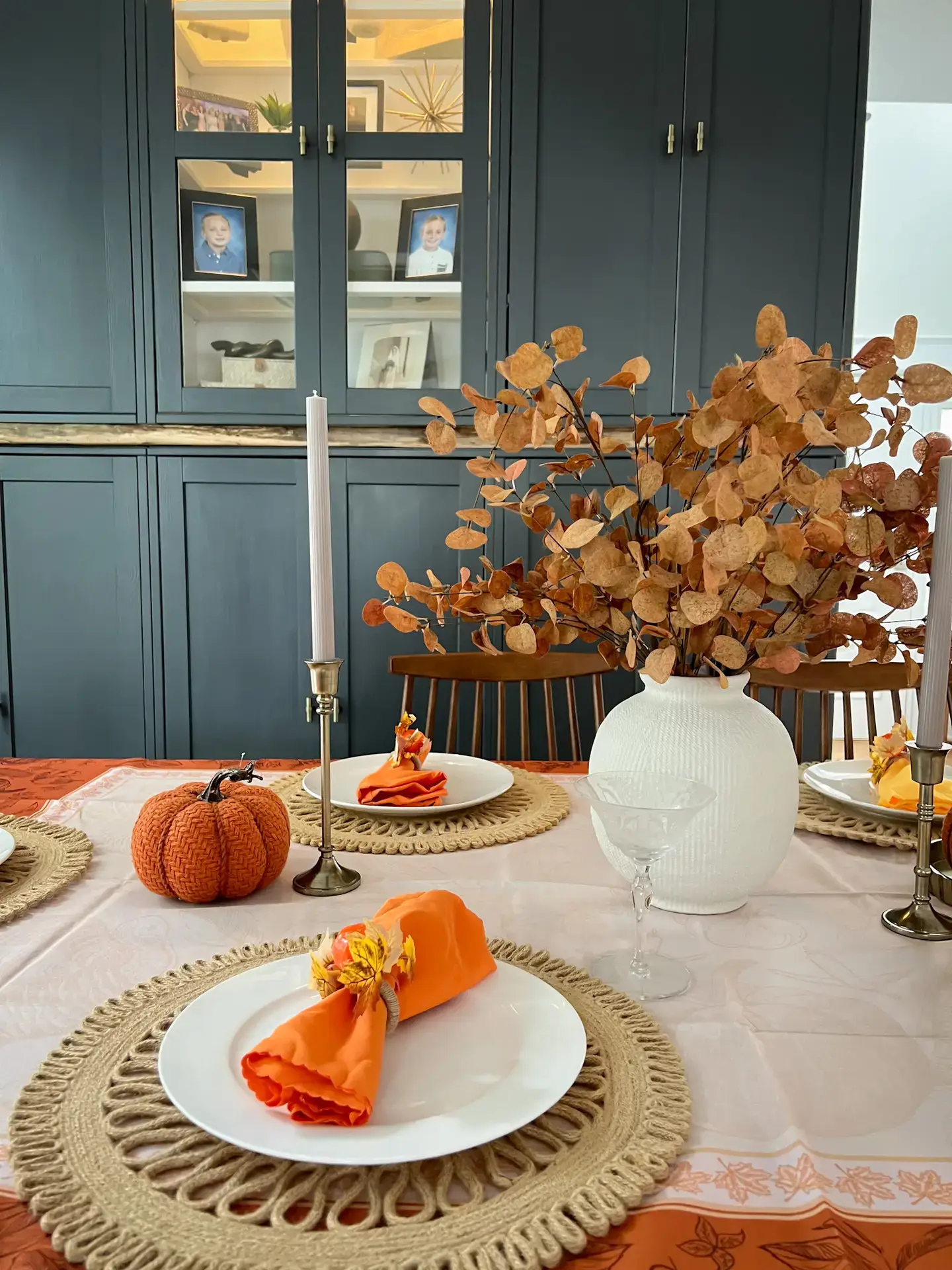 A table set with plates, napkins and candles.