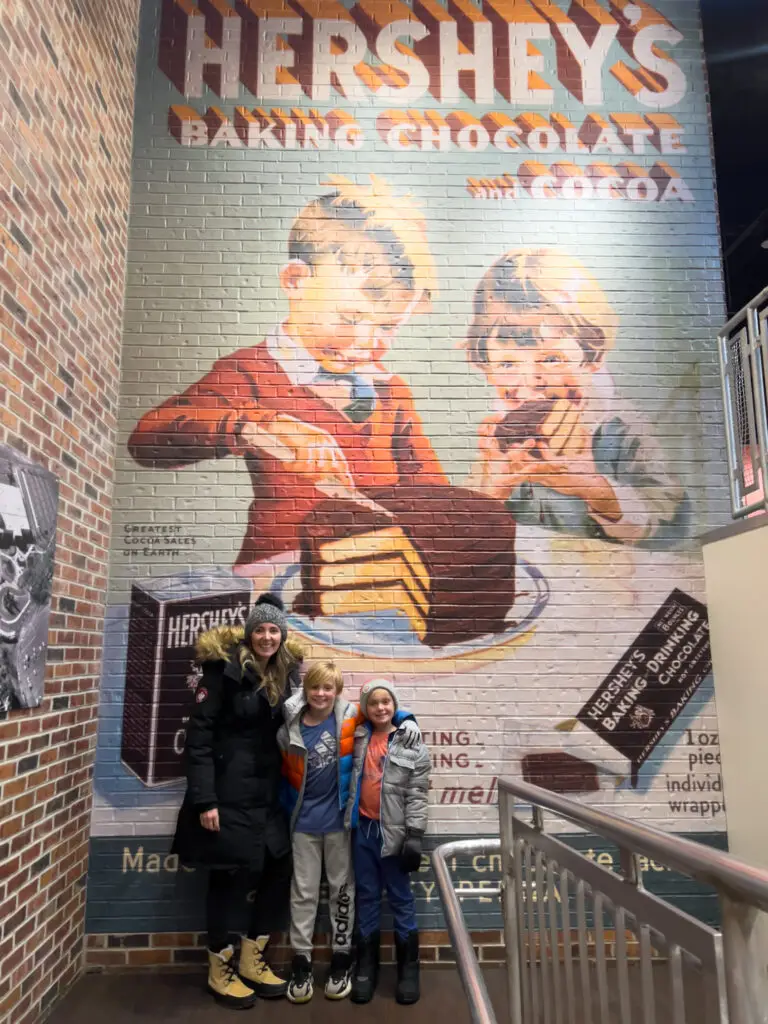 The-Ultimate-Weekend-in-Hershey-Holiday-Getaway-Guide - Sweet Motherly A mural of two girls and a boy in front of a wall.