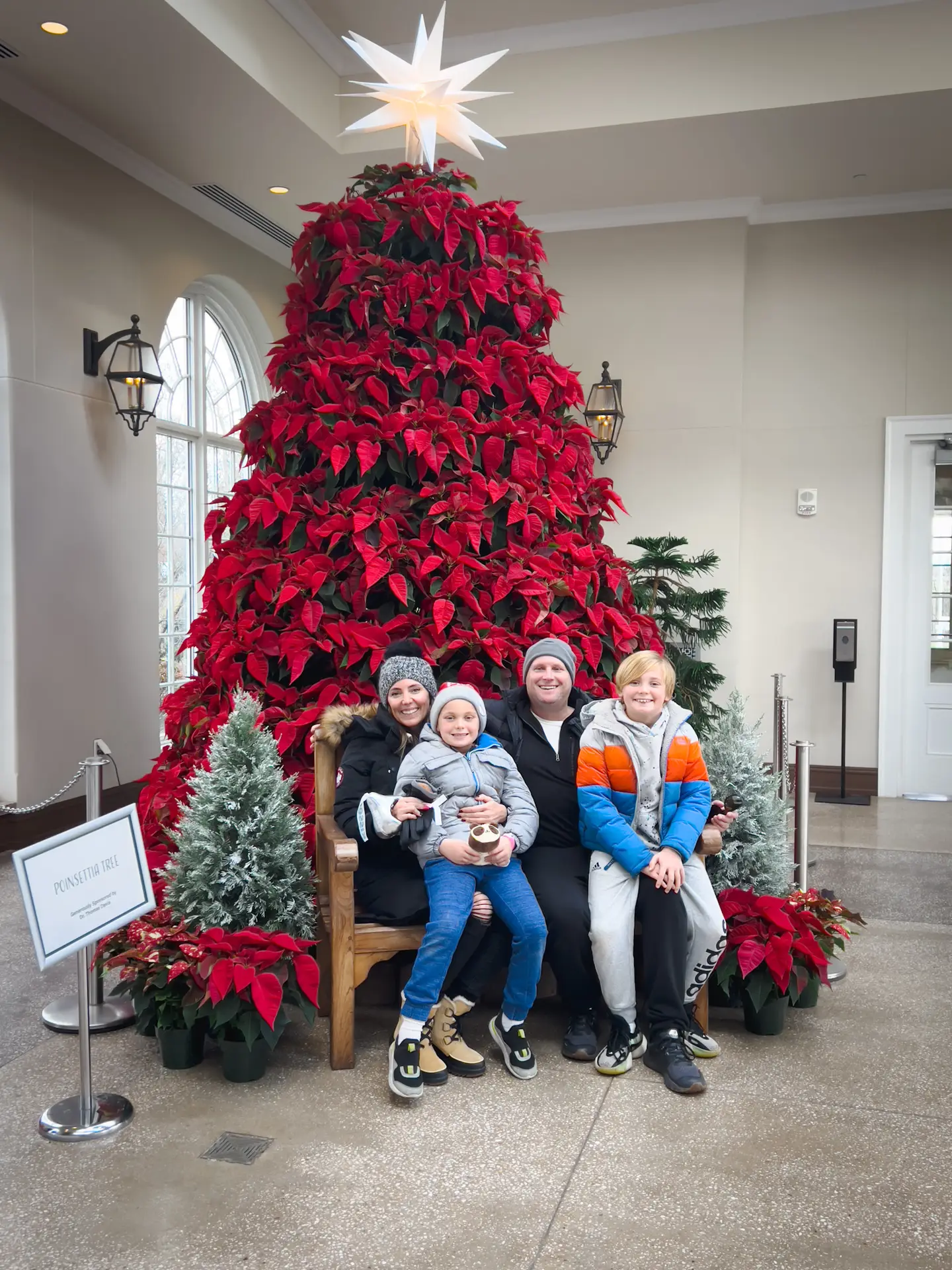 A group of people sitting in front of a christmas tree.
