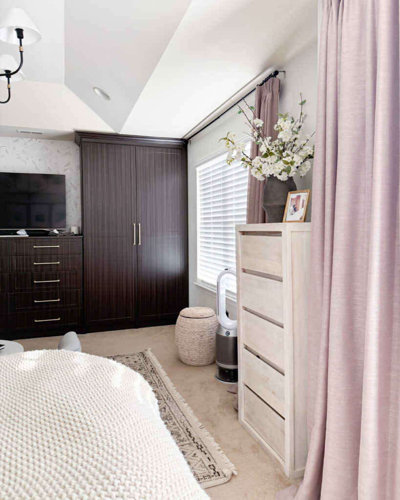 Mauve curtains framing large windows, complementing the neutral furniture and dark built-in cabinets for a cozy, finished look.