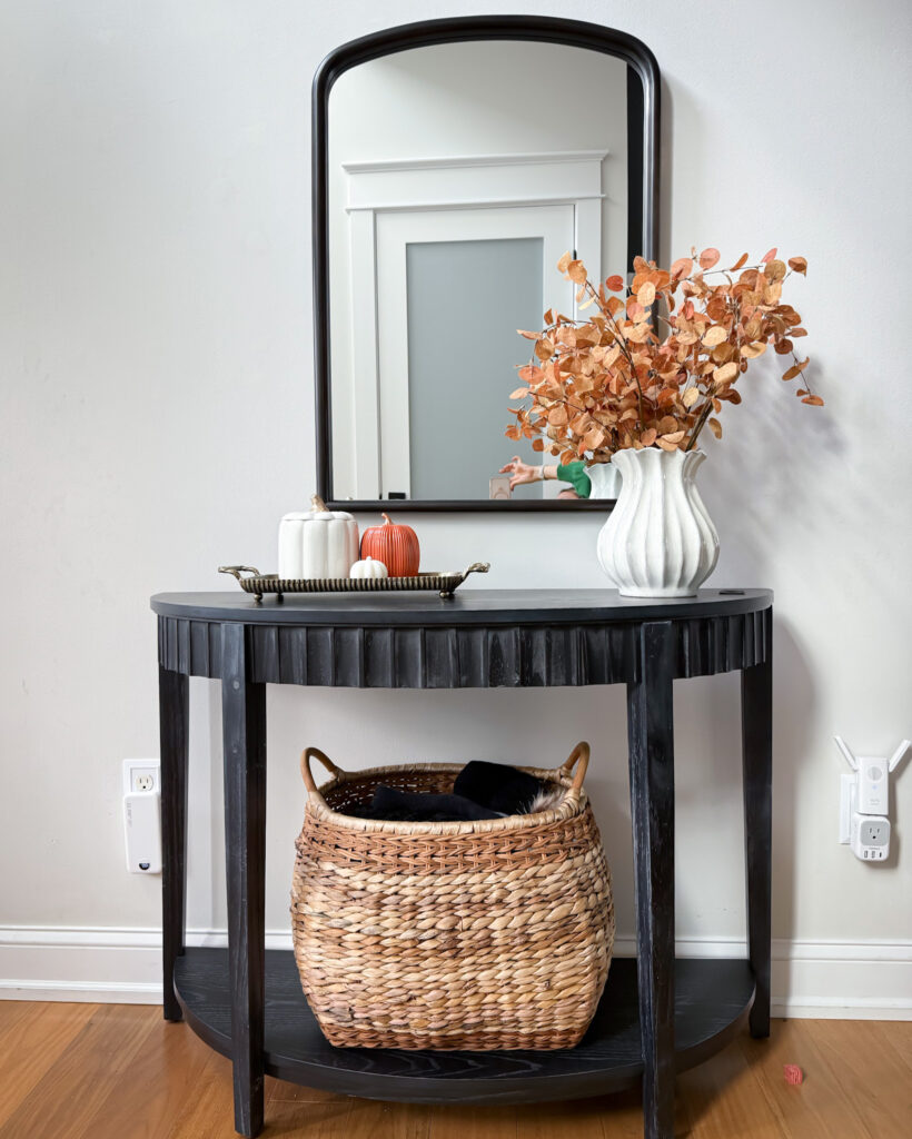 IMG_4356 - Sweet Motherly Black entryway table with round mirror, white vase of dried stems, and small pumpkins styled for fall decor