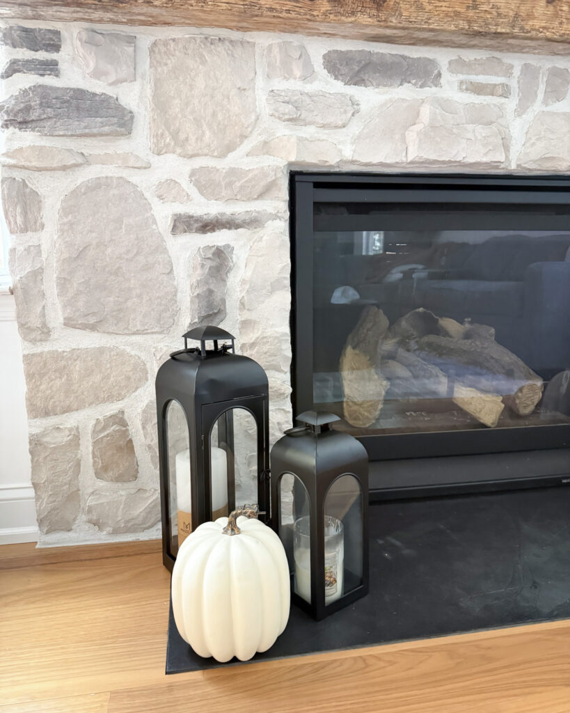 IMG_4392 - Sweet Motherly Neutral fall fireplace styling with black lanterns, white and orange pumpkins, and stone surround