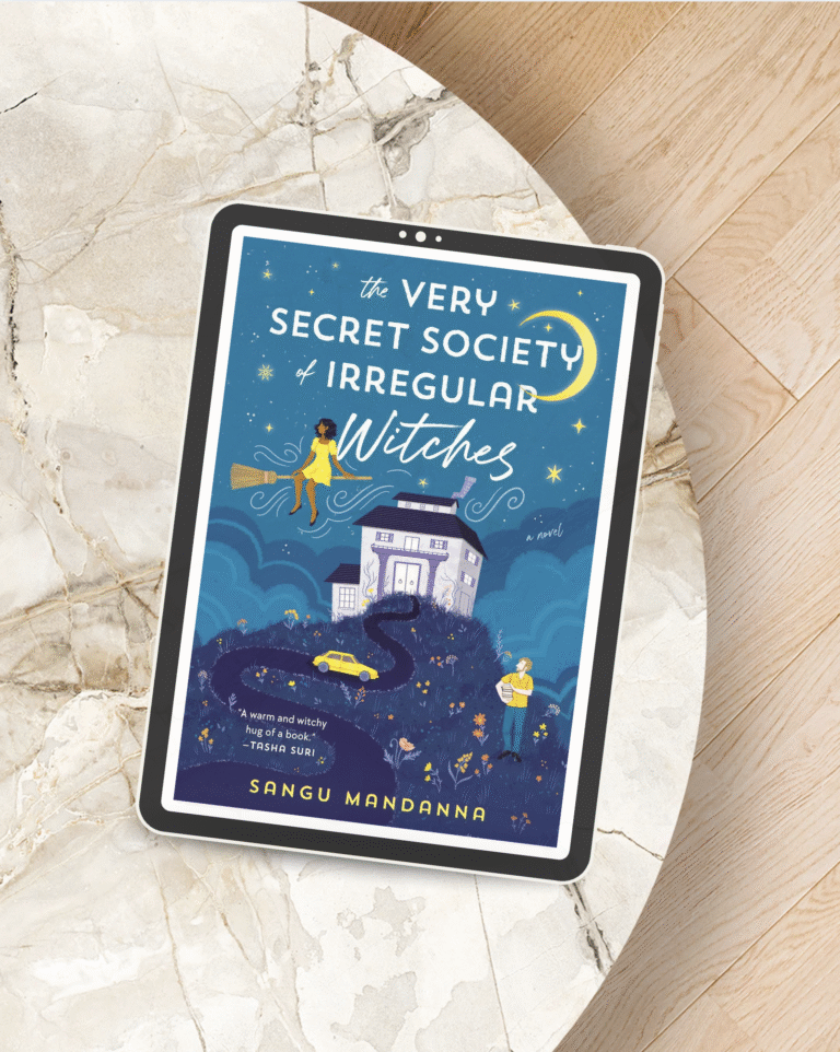 Digital book cover of “The Very Secret Society of Irregular Witches” by Sangu Mandanna displayed on a tablet, featuring a whimsical illustration of a witch on a broom flying over a cozy house at night. October Book Club