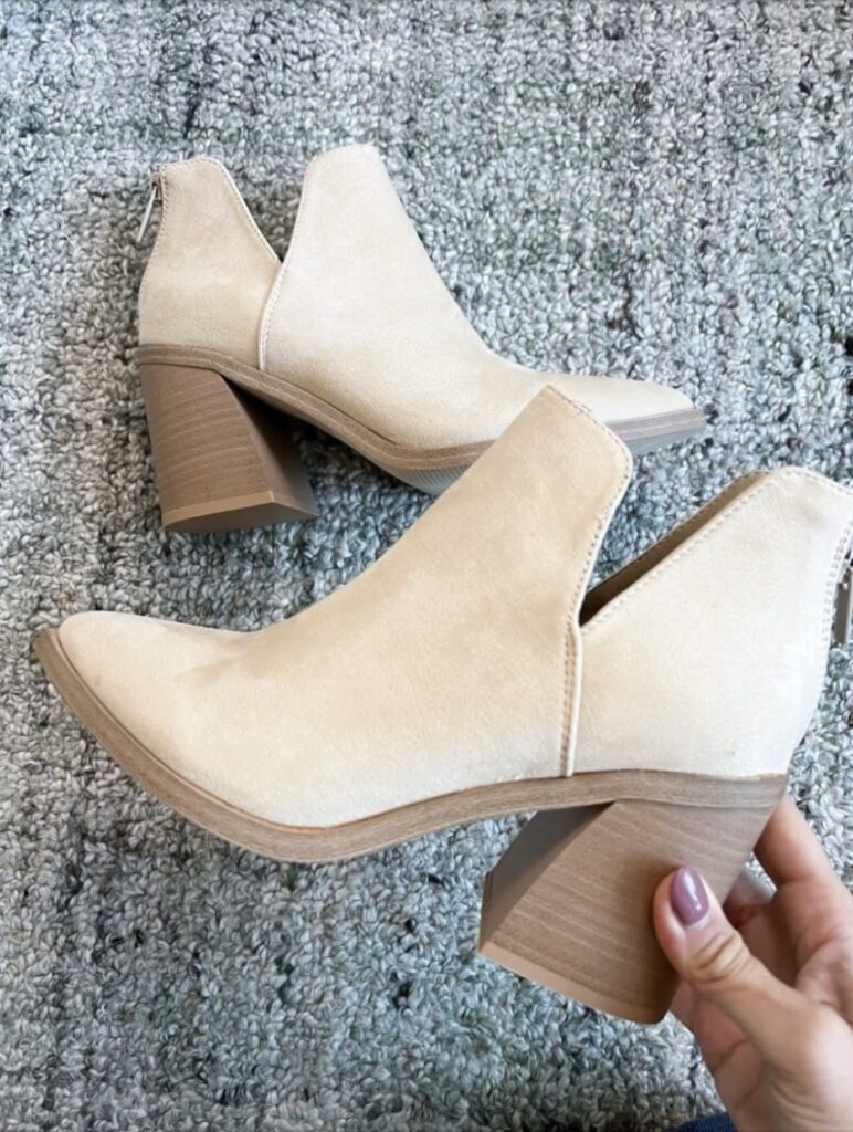 Close up of beige suede Amazon block heel booties on a textured rug. Neutral winter boots styled for everyday outfits.