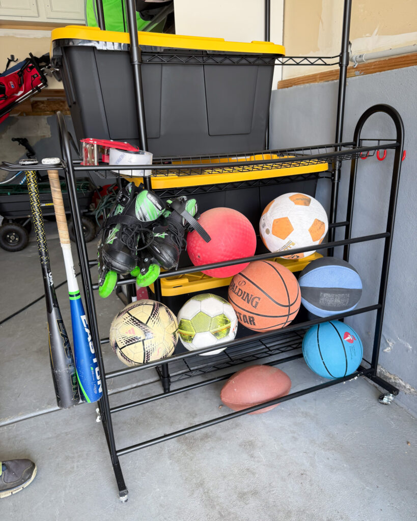 Garage wall rack organizing kids’ sports balls and outdoor play equipment.
