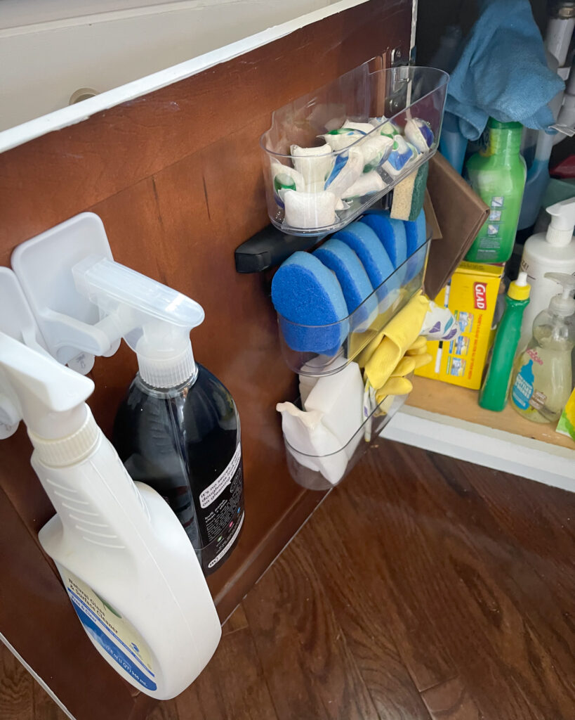 Under-sink cabinet with pull-out storage shelves organizing cleaning supplies.