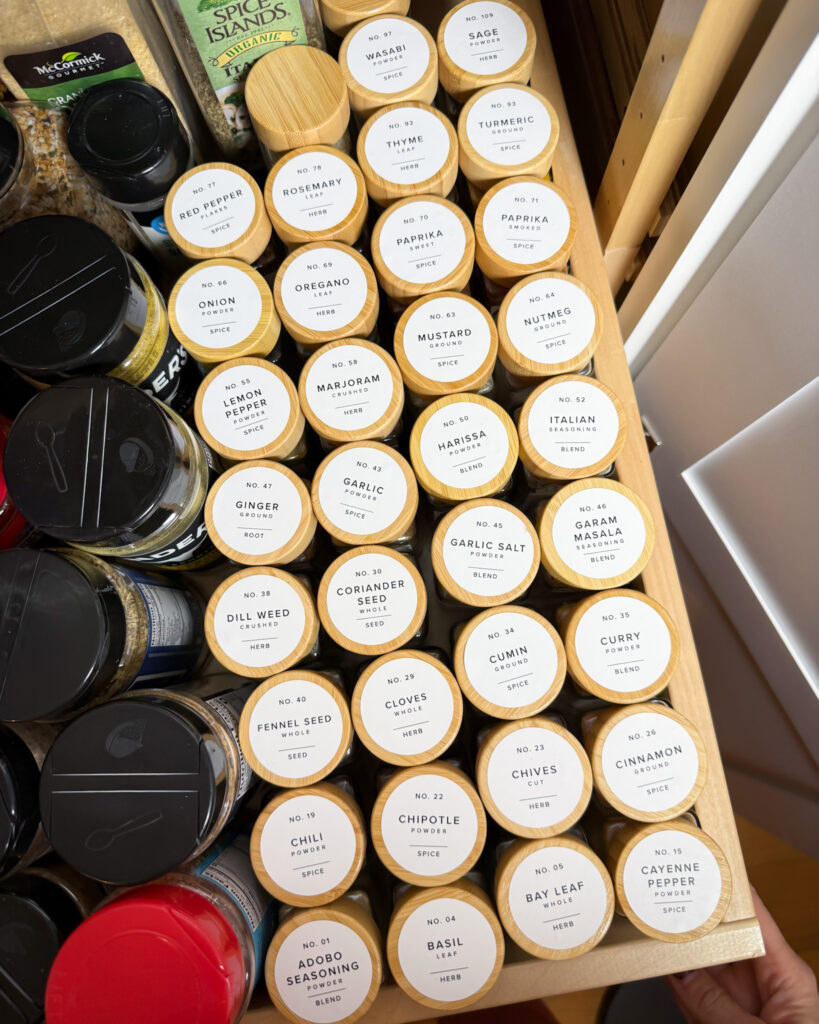 Organized spice drawer with labels visible and spices neatly arranged.