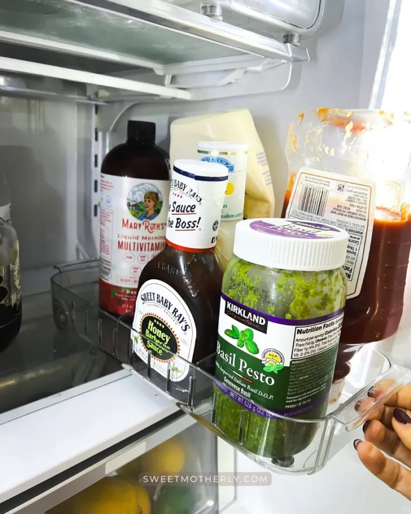 Pull-out fridge bins holding sauces and bottles for easy access.