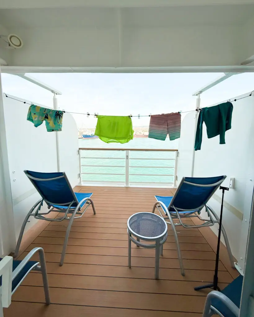 IMG_9280 - Sweet Motherly Cruise ship balcony with swimsuits and clothing hanging on a line using magnetic hooks – smart Cruise Essentials from Amazon for extra drying space.