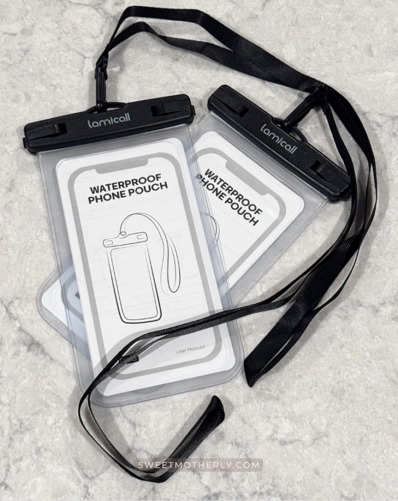 Image 1-16-26 at 646 AM - Sweet Motherly Waterproof phone pouch with black lanyard straps, shown flat on a light marble surface—clear protective case labeled “Waterproof Phone Pouch,” a practical Cruise Essentials from Amazon item for keeping your phone safe at the pool, beach, or on shore excursions.