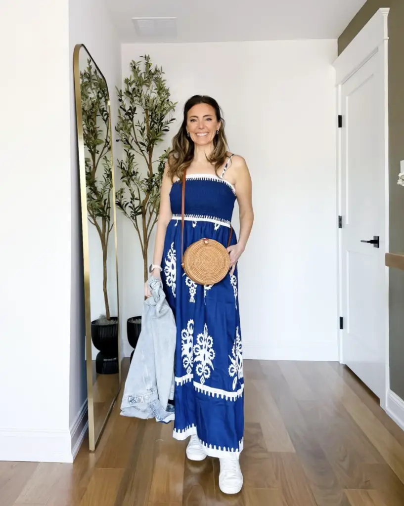 Screenshot 2026-02-02 at 101613 AM - Sweet Motherly Woman styled in a navy and white printed maxi dress with white sneakers, a round woven crossbody bag, and a denim jacket for effortless affordable resort wear styling.