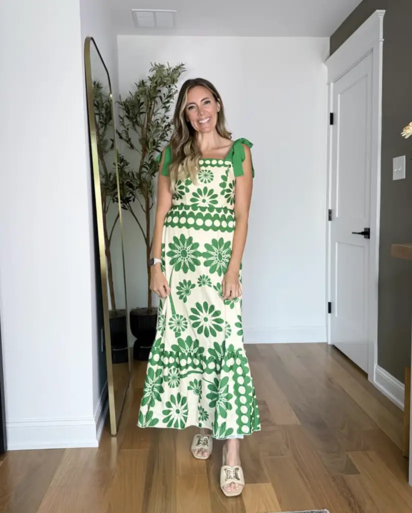 Screenshot 2026-02-02 at 95303 AM - Sweet Motherly Woman wearing a green and cream floral midi dress with bow tie straps and neutral slide sandals, styled as affordable resort wear for tropical trips.