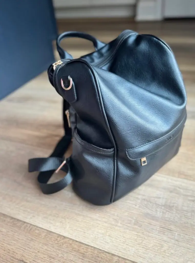 Black leather travel backpack with top handle and zipper pocket, a stylish and functional family travel essential from Amazon.