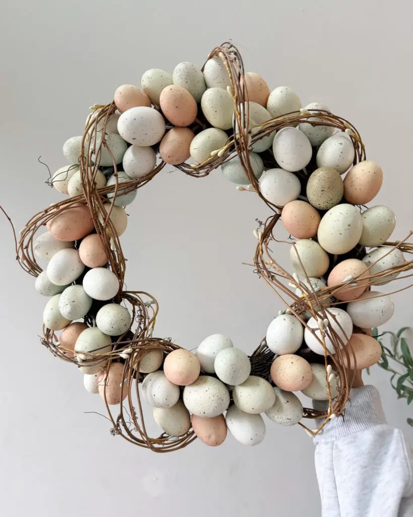 Pastel Easter egg wreath made of speckled eggs and twigs, spring door decor