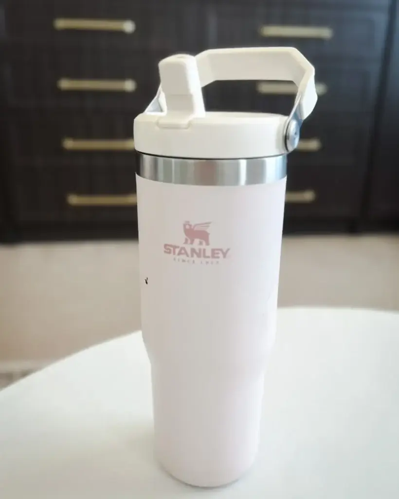 White Stanley insulated travel tumbler with handle and flip lid, a practical family travel essential from Amazon for staying hydrated on the go.