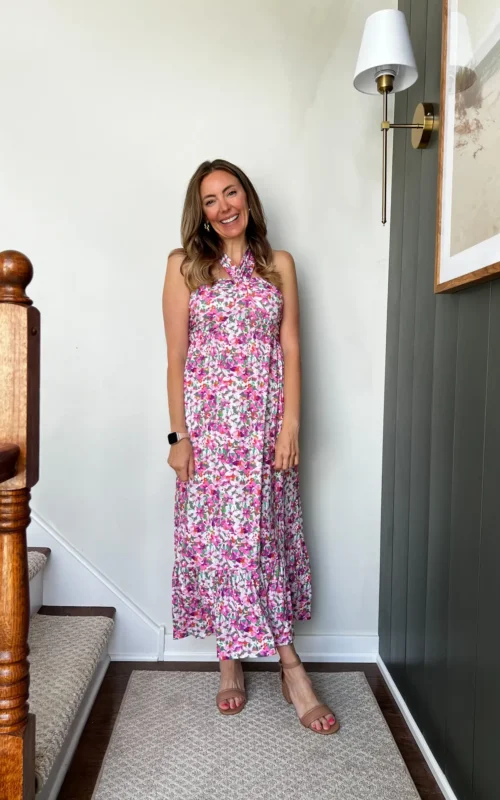 A woman standing on the stairs wearing a dress.
